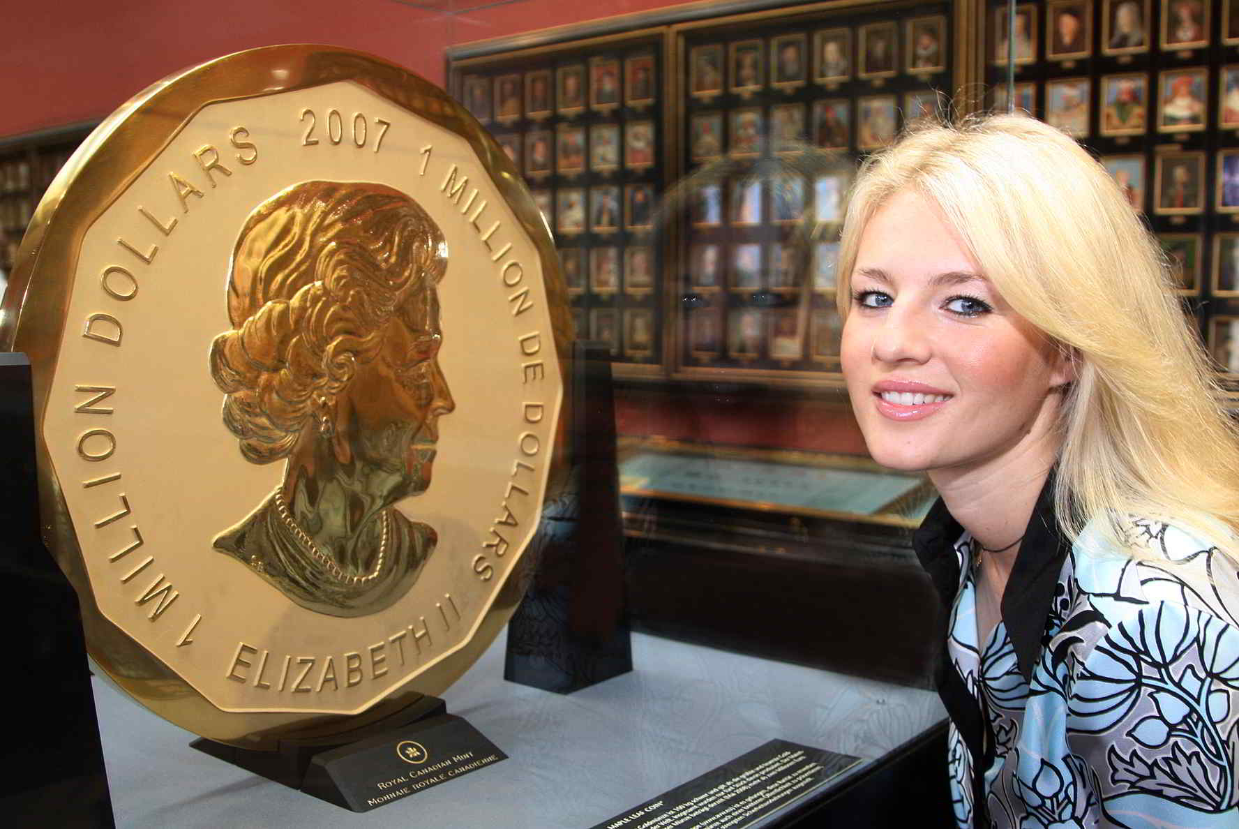 Blond-haired model poses next to display cabinet featuring world's largest gold coin