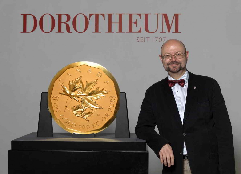 Coin specialist poses with world's largest gold coin