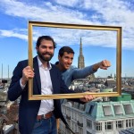 Team clowning with picture frame atop roof over Vienna