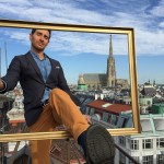 Man stepping through picture frame on rooftop in Vienna