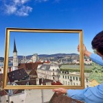 Picture frame held up against sky and cityscape over rooftops of Vienna