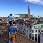 Fotograf macht sich bereit, während der Helfer den Bilderrahmen in Richtung Stephansdom positioniert